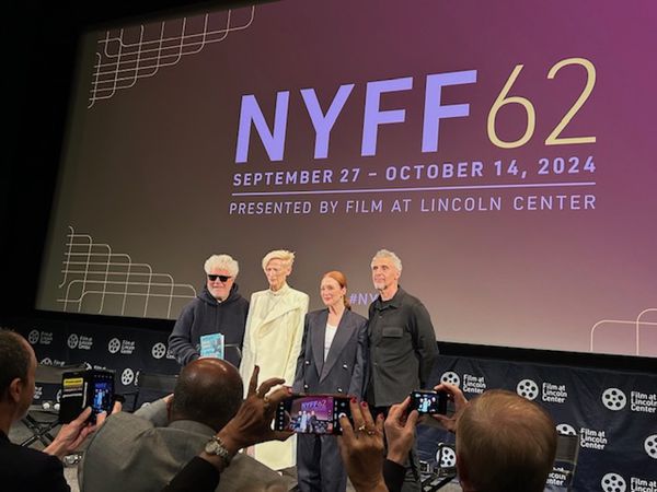 Pedro Almodóvar (holding up a copy of Sigrid Nunez's What Are You Going Through) with Tilda Swinton, Julianne Moore and John Turturro at The Room Next Door press conference